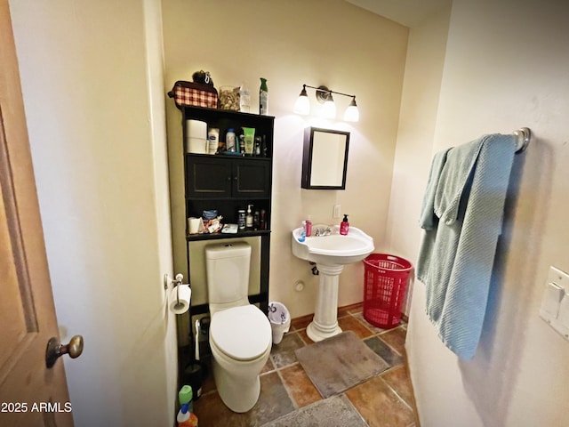 half bathroom with baseboards and toilet