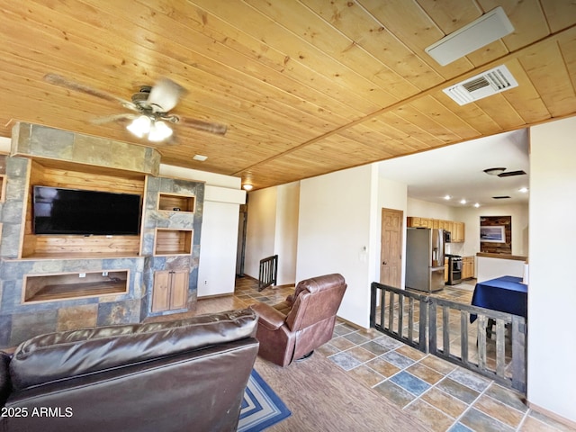 living room featuring wooden ceiling, a fireplace, visible vents, and a ceiling fan