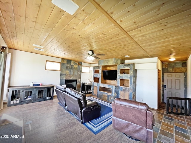 living area featuring visible vents, a tiled fireplace, wood ceiling, ceiling fan, and wood finished floors