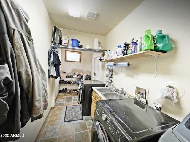 washroom with laundry area, visible vents, separate washer and dryer, and a sink