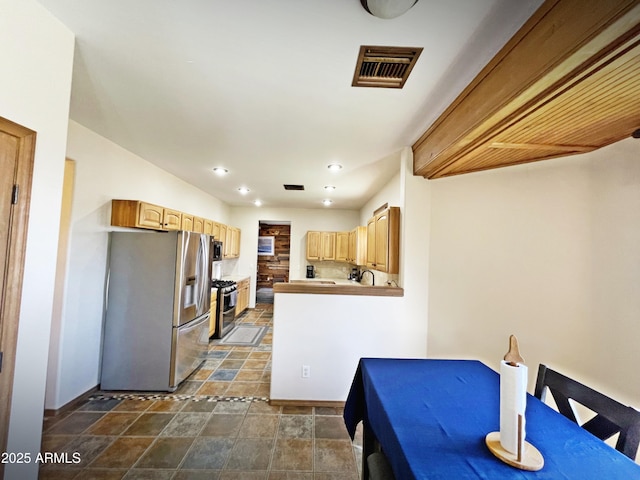 kitchen with recessed lighting, visible vents, appliances with stainless steel finishes, stone finish floor, and light brown cabinets