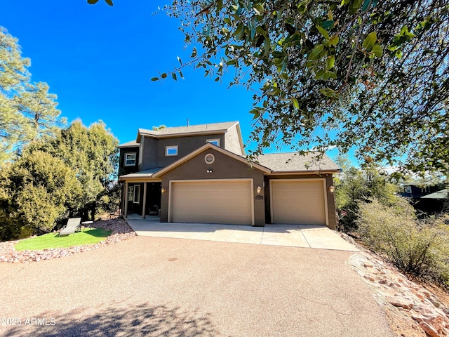 view of front of house featuring driveway, an attached garage, and stucco siding