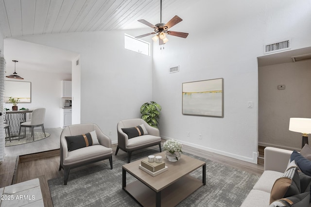 living area featuring lofted ceiling, wood finished floors, ceiling fan, and baseboards