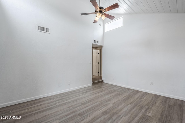 spare room featuring a ceiling fan, wood finished floors, baseboards, and high vaulted ceiling