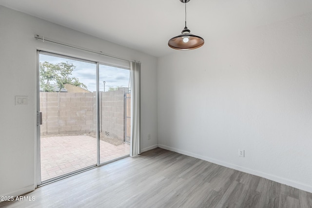 unfurnished dining area featuring wood finished floors and baseboards