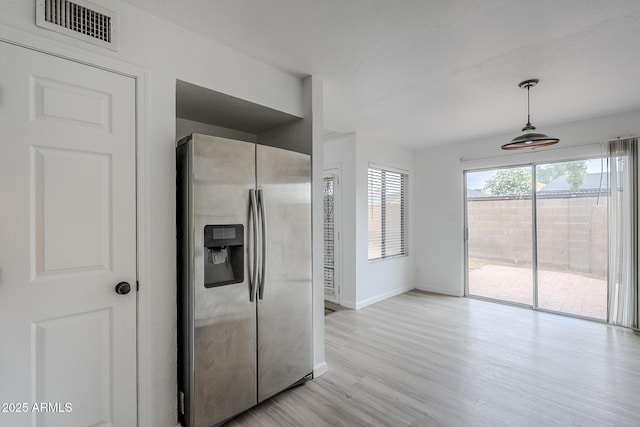 kitchen featuring stainless steel fridge with ice dispenser, light wood-style flooring, baseboards, and pendant lighting