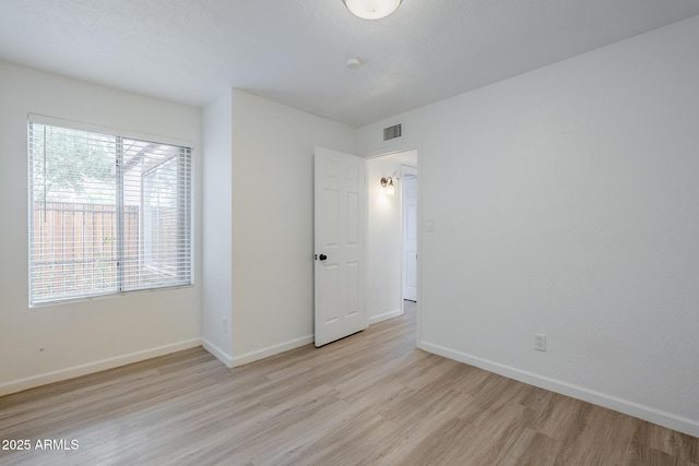 spare room with wood finished floors and baseboards