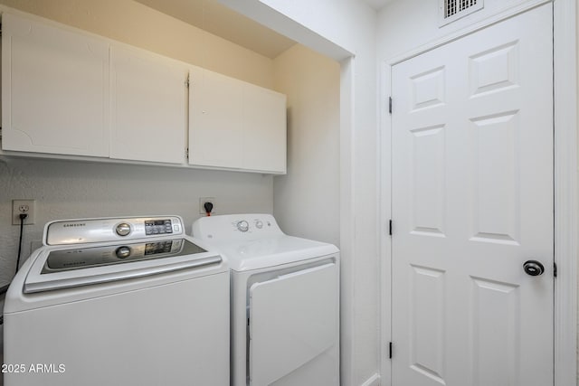 laundry room featuring washing machine and clothes dryer and cabinet space