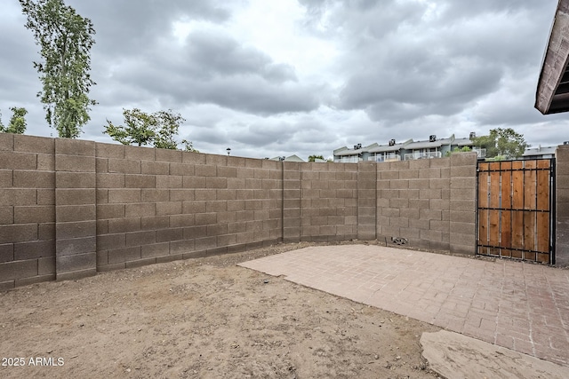 view of yard with fence, a patio, and a gate