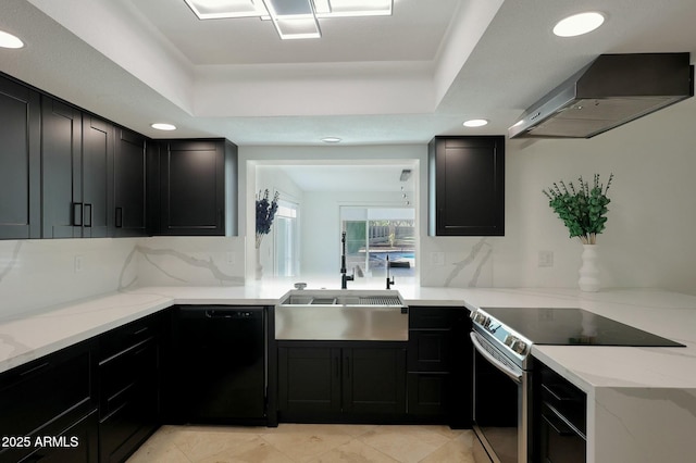 kitchen featuring a tray ceiling, stainless steel range with electric cooktop, a sink, dishwasher, and wall chimney exhaust hood