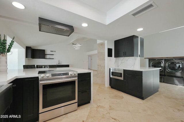 kitchen featuring dark cabinets, visible vents, light countertops, appliances with stainless steel finishes, and washer and clothes dryer
