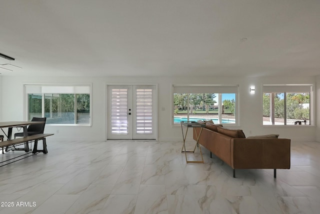 living area featuring marble finish floor and french doors