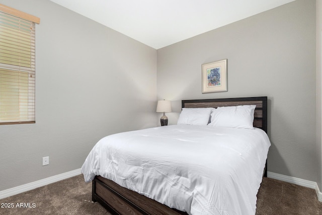 bedroom featuring dark carpet and baseboards