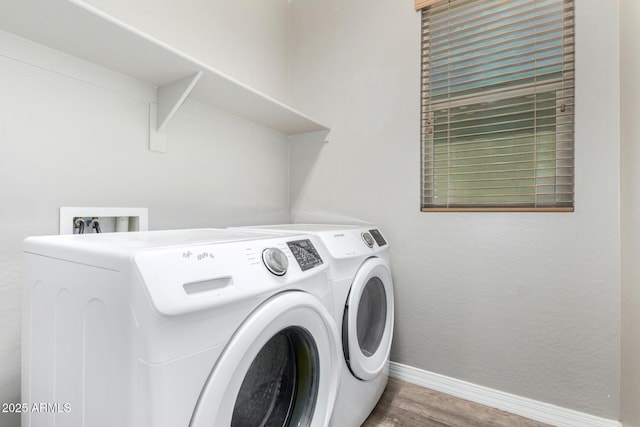 clothes washing area featuring laundry area, independent washer and dryer, baseboards, and wood finished floors