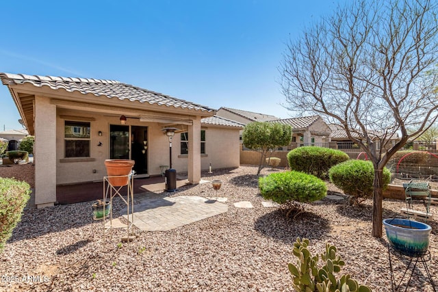 back of property with a patio, a tile roof, fence, and stucco siding