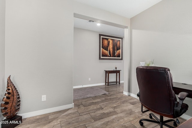 office area with light wood-style floors and baseboards