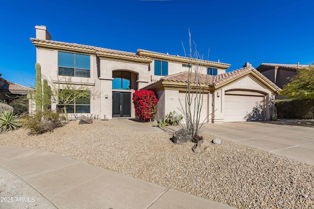 mediterranean / spanish home with a garage, a tile roof, concrete driveway, stucco siding, and a chimney