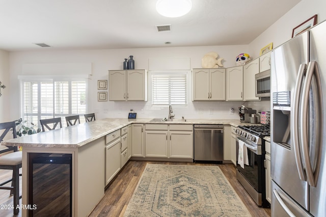 kitchen featuring appliances with stainless steel finishes, sink, tasteful backsplash, and cream cabinets