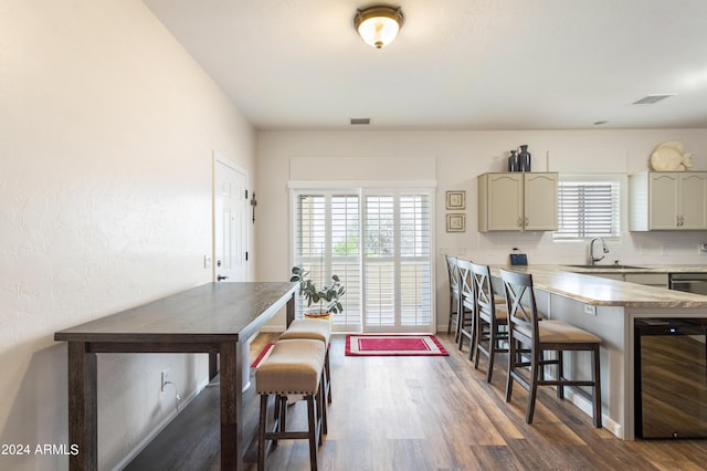 kitchen with plenty of natural light, a kitchen bar, sink, and beverage cooler