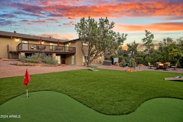 exterior space featuring a wooden deck, a lawn, and a patio area