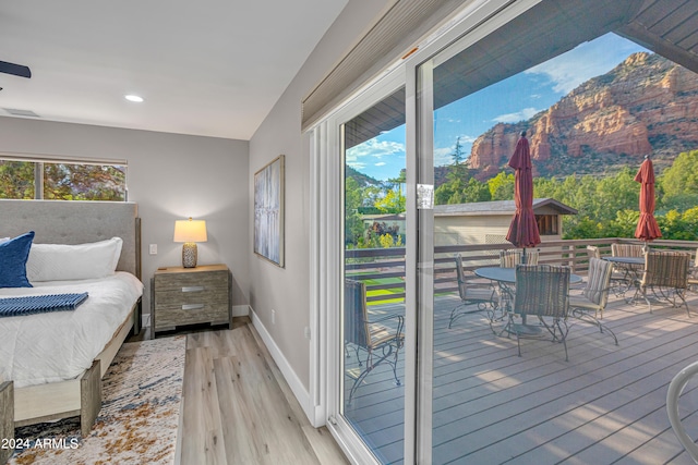 bedroom featuring light hardwood / wood-style flooring, lofted ceiling, and access to exterior