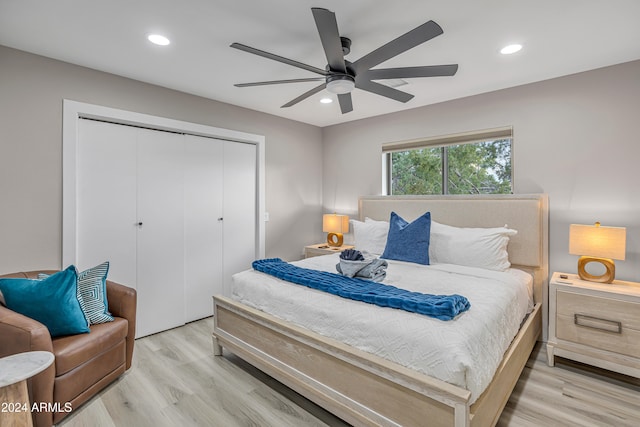 bedroom featuring ceiling fan, light wood-type flooring, and a closet