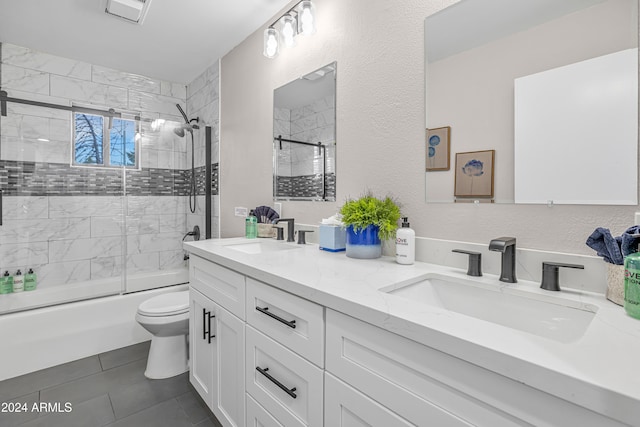 full bathroom with shower / bath combination with glass door, vanity, toilet, and tile patterned floors