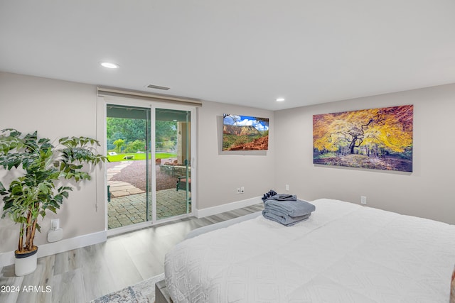 bedroom featuring wood-type flooring and access to exterior