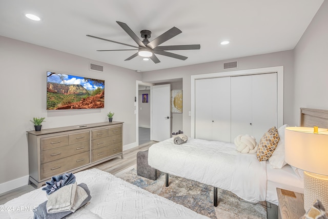 bedroom with light hardwood / wood-style flooring, a closet, and ceiling fan