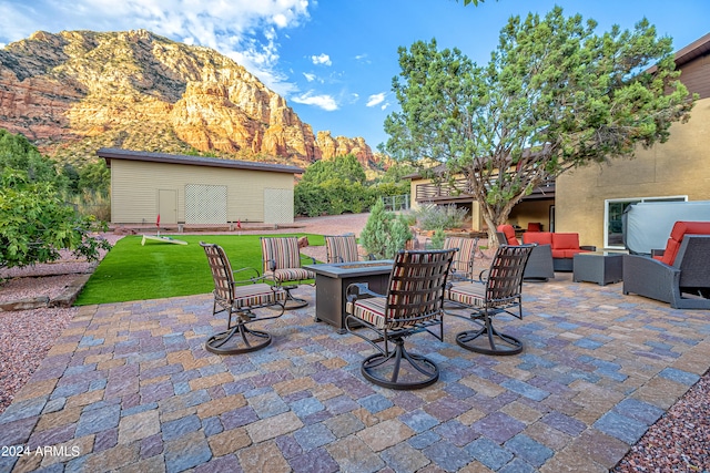 view of patio with a mountain view and an outdoor living space with a fire pit