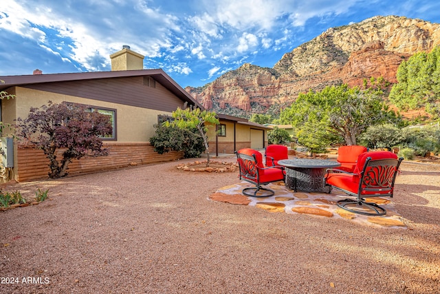 exterior space with a mountain view and an outdoor fire pit