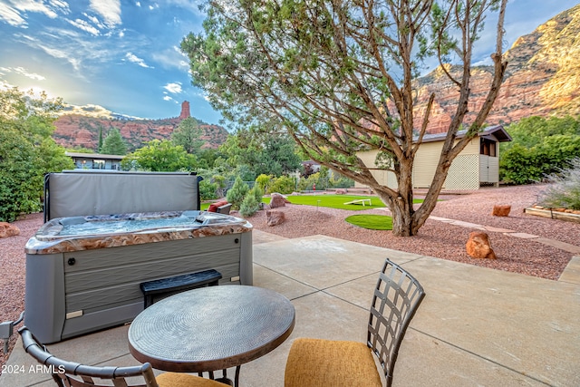 view of patio with a hot tub and a mountain view