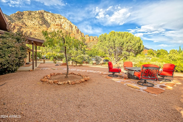 view of yard with an outdoor fire pit, a mountain view, and a patio area