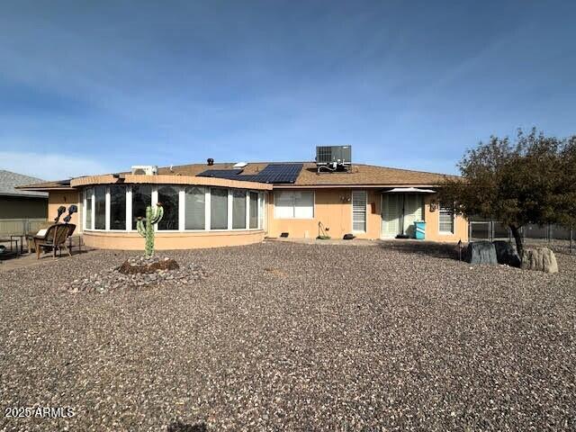 back of house with cooling unit and solar panels