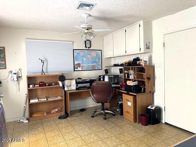 home office with a textured ceiling and ceiling fan