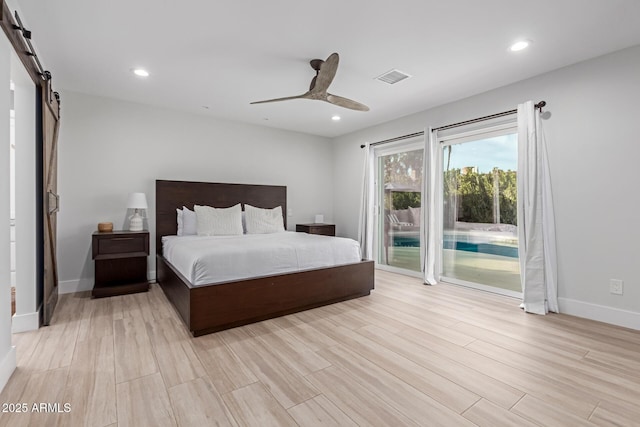 bedroom with light hardwood / wood-style flooring, access to outside, a barn door, and ceiling fan