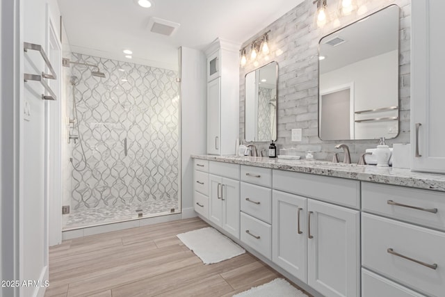 bathroom featuring hardwood / wood-style flooring, vanity, and a shower with shower door