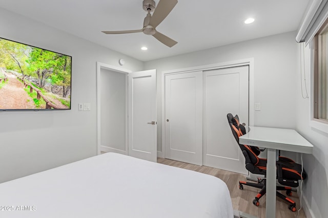 bedroom featuring light hardwood / wood-style floors, a closet, and ceiling fan