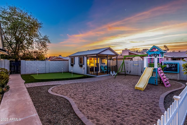 playground at dusk featuring an outbuilding