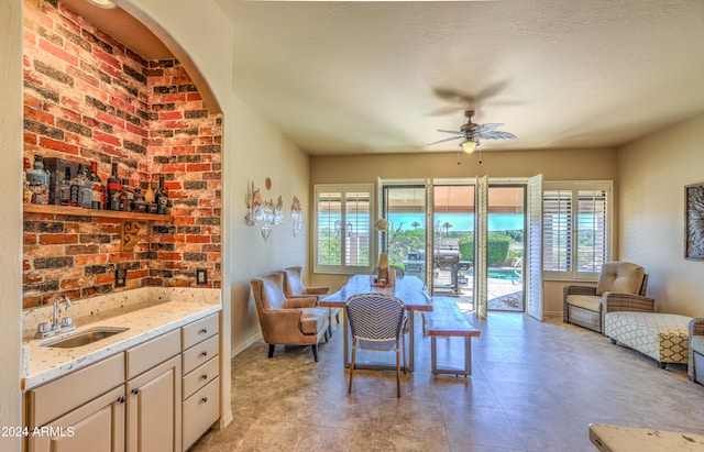 dining area with sink, plenty of natural light, ceiling fan, and light tile floors