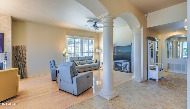 tiled living room with ceiling fan and ornate columns