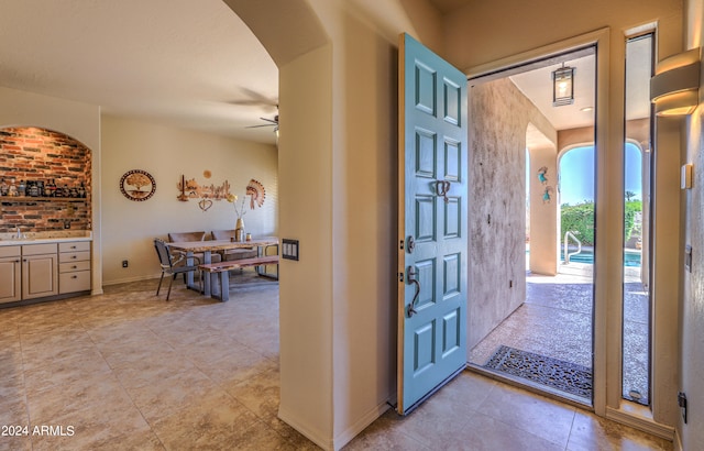 tiled entrance foyer with sink and ceiling fan