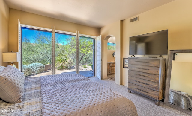 bedroom with light colored carpet and access to exterior