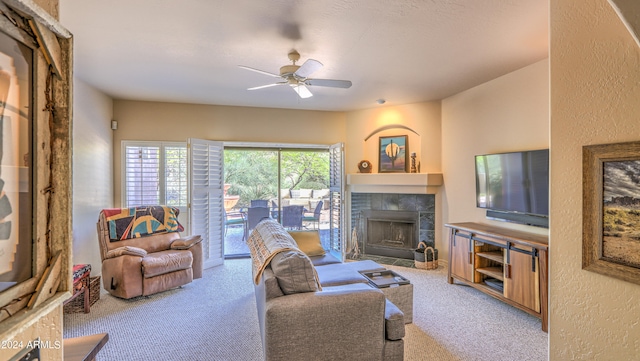 living room with light carpet, ceiling fan, and a tiled fireplace