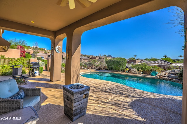 view of pool with a patio, ceiling fan, and a fire pit