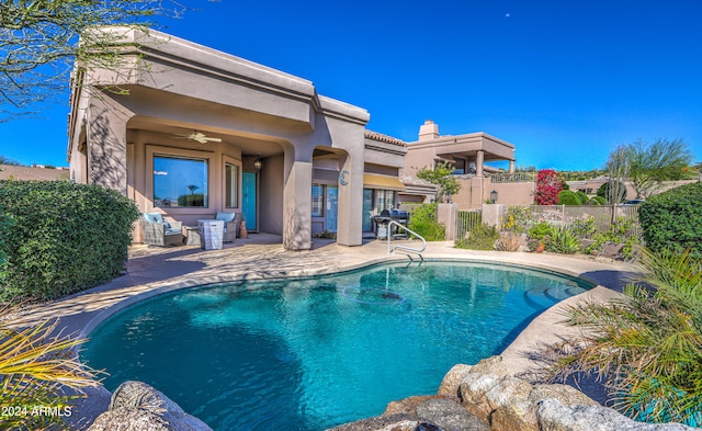 view of pool with ceiling fan, grilling area, and a patio area