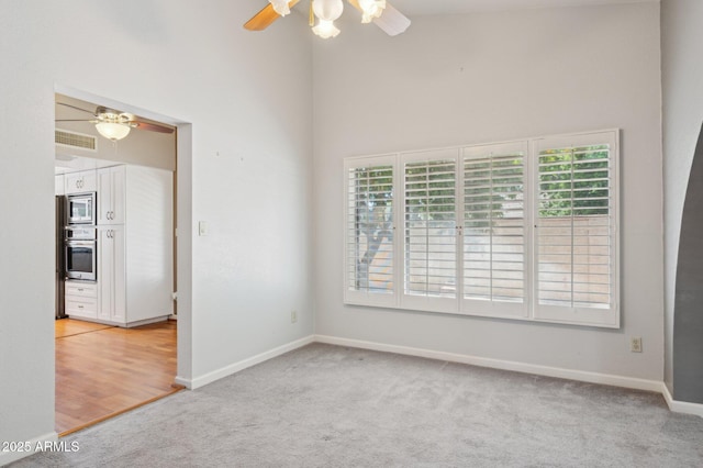 2053 W Natal Cir, Mesa, AZ 85202 - spare room featuring a ceiling fan, light colored carpet, plenty of natural light, and a high ceiling