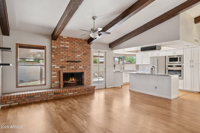 2053 W Natal Cir, Mesa, AZ 85202 - unfurnished living room featuring light wood-style flooring, a ceiling fan, and a fireplace
