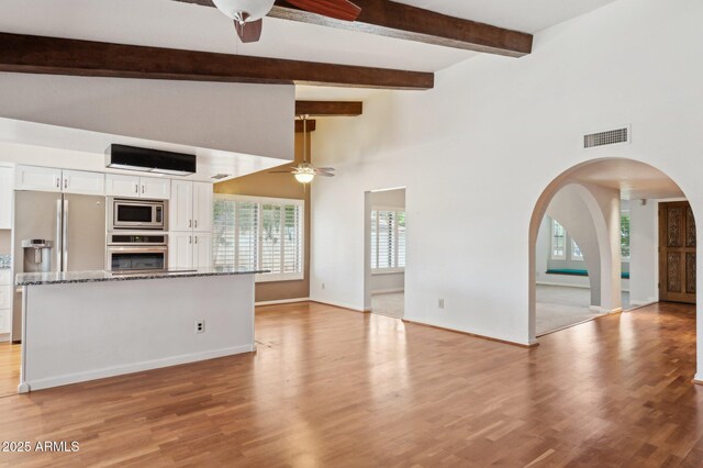2053 W Natal Cir, Mesa, AZ 85202 - unfurnished living room with a ceiling fan, light wood finished floors, arched walkways, beamed ceiling, and a high ceiling