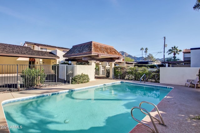 pool featuring fence, a patio, and a gazebo